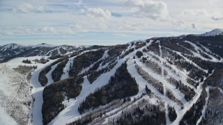 AX126_123 - 5.5K aerial stock footage orbiting snowy ski runs and lift at Park City Mountain Resort in winter, Utah