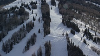 AX126_125 - 5.5K aerial stock footage orbit ski lift and skiers at Park City Mountain Resort in winter, Utah