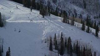 AX126_126E - 5.5K aerial stock footage of skiers on a run at Park City Mountain Resort in winter, Utah