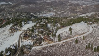 AX126_134E - 5.5K aerial stock footage orbit ski lift and mountaintop mansions at Deer Valley in winter, Utah