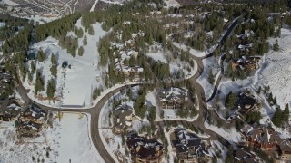AX126_141 - 5.5K aerial stock footage fly over mansions and a ski lift in Deer Valley with winter snow in Utah