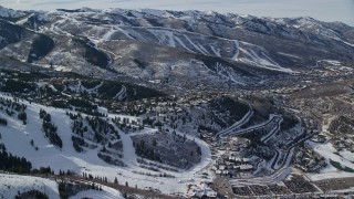 AX126_146E - 5.5K aerial stock footage of hilltop homes near the small town of Park City with winter snow, Utah