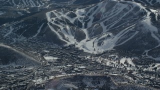 AX126_155 - 5.5K aerial stock footage of small mountain town beside ski slopes in winter, Park City, Utah