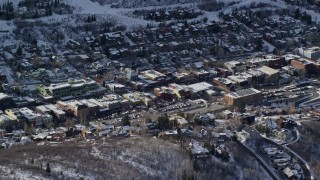 AX126_175 - 5.5K aerial stock footage orbit shops in Park City's town center with winter snow, Utah