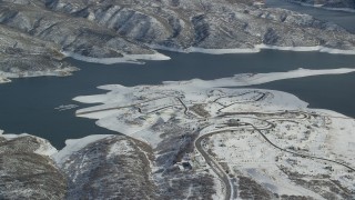 AX126_180 - 5.5K aerial stock footage orbit roads on the shore of the Jordanelle Reservoir in wintertime, Heber City, Utah