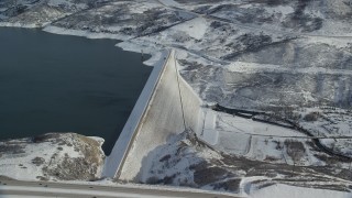 AX126_183 - 5.5K aerial stock footage of slowly orbit the Jordanelle Dam with light winter snow, Heber City, Utah