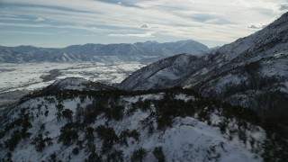 AX126_189 - 5.5K aerial stock footage pan and fly over snowy Wasatch Range mountain ridge in winter, Utah