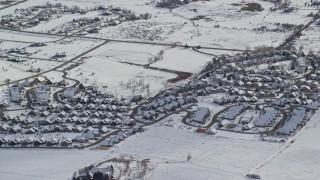 AX126_200 - 5.5K aerial stock footage orbit tract homes with snowy rooftops in the small town of Midway, Utah