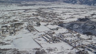 AX126_206 - 5.5K stock footage aerial video orbit small town homes covered in winter snow, Midway, Utah
