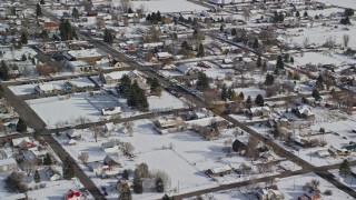 AX126_208E - 5.5K aerial stock footage of flying over homes with snow on rooftops in winter, Midway, Utah
