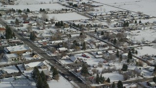 AX126_210 - 5.5K stock footage aerial video of flying over snowy small town neighborhoods in winter, Midway, Utah