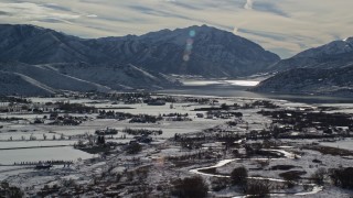 AX126_213 - 5.5K aerial stock footage orbit Deer Creek Reservoir by Heber City with winter snow, Utah