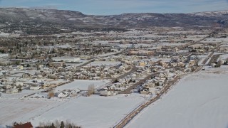 AX126_215 - 5.5K aerial stock footage orbit homes with winter snow on the outskirts of Heber City, Utah