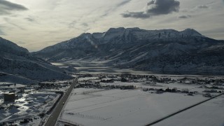 AX126_220 - 5.5K aerial stock footage approach frozen shore of Deer Creek Reservoir and mountains in winter, Heber City, Utah
