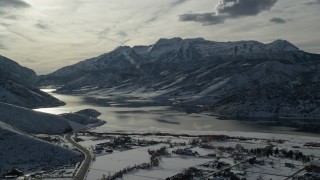 AX126_222 - 5.5K aerial stock footage approach snowy mountains by icy Deer Creek Reservoir in winter, Heber City, Utah