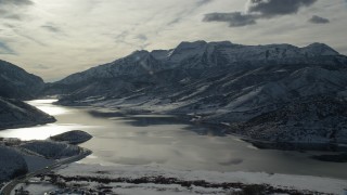 AX126_223 - 5.5K aerial stock footage approach Icy Deer Creek Reservoir and snowy Wasatch Range mountains in winter, Utah