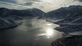 AX126_225 - 5.5K aerial stock footage orbit sunlight reflected off Deer Creek Reservoir in wintertime, Utah