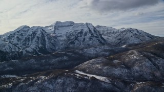 AX126_237E - 5.5K aerial stock footage of rugged Mount Timpanogos with winter snow in the Wasatch Range of Utah