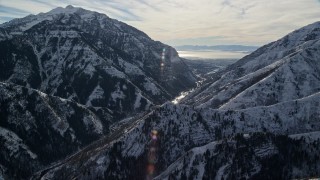 AX126_240E - 5.5K aerial stock footage approach Provo Canyon through snowy Wasatch Range in wintertime, Utah