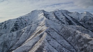 AX126_243E - 5.5K aerial stock footage of tall Mount Timpanogos with winter snow in Utah