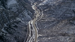 AX126_248E - 5.5K aerial stock footage of bird's eye of Provo Canyon Road through the snowy Wasatch Range in winter, Utah