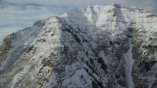 AX126_251 - 5.5K aerial stock footage flyby steep, snowy slopes of Mount Timpanogos in winter, Utah