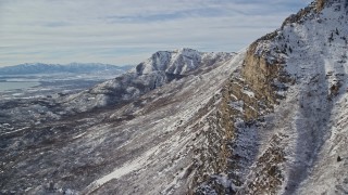 AX126_252E - 5.5K aerial stock footage of rocky slopes of Mount Timpanogos with winter snow in Utah