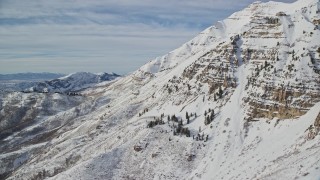 AX126_257E - 5.5K aerial stock footage of snow covered slopes of Mount Timpanogos in wintertime, Utah