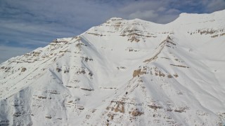 AX126_260E - 5.5K aerial stock footage of Mount Timpanogos slopes covered in winter snow in Utah