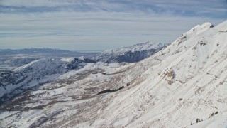 AX126_263E - 5.5K aerial stock footage fly over frozen Mount Timpanogos slopes in wintertime, Utah