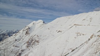 AX126_265 - 5.5K aerial stock footage of steep slopes with winter snow on Mount Timpanogos, Utah