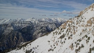 AX126_269E - 5.5K stock footage video pan across northern slopes of Mount Timpanogos to distant mountains in winter, Utah