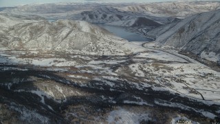 AX126_301 - 5.5K aerial stock footage approach Deer Creek Reservoir beyond a snowy valley in winter, Utah