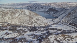 AX126_301E - 5.5K aerial stock footage approach Deer Creek Reservoir beyond a snowy valley in winter, Utah