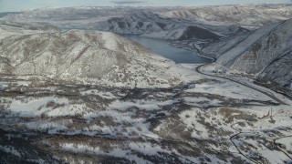 AX126_302 - 5.5K aerial stock footage fly over snowy valley to approach Deer Creek Reservoir in winter, Utah