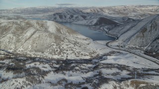 AX126_303 - 5.5K aerial stock footage approach Deer Creek Reservoir from a snowy, hilly valley in winter, Utah