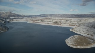 AX126_316 - 5.5K aerial stock footage approach snowy Heber City from icy Deer Creek Reservoir in winter, Utah