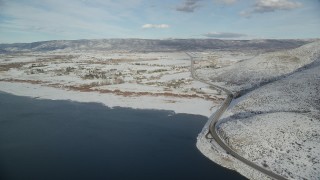 AX126_317 - 5.5K aerial stock footage approach Heber City from reservoir, pan to highway with winter snow, Utah