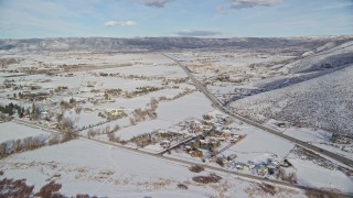 AX126_317E - 5.5K aerial stock footage approach Heber City from reservoir, and fly over the town with winter snow, Utah