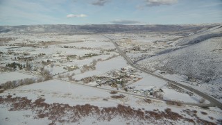 AX126_318 - 5.5K aerial stock footage fly over homes in Heber City with winter snow near the highway, Utah