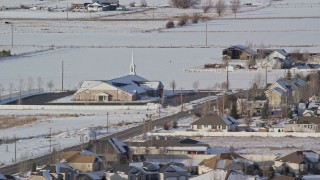 AX126_324 - 5.5K stock footage aerial video orbit a church near homes with winter snow, Heber City, Utah