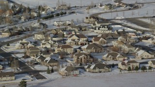 AX127_003 - 5.5K aerial stock footage of tract homes with winter snow in a small town, Heber City, Utah