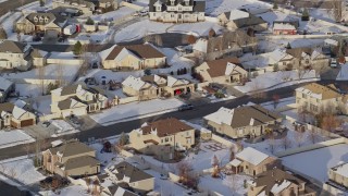 AX127_003E - 5.5K aerial stock footage of tract homes with winter snow in a small town, Heber City, Utah