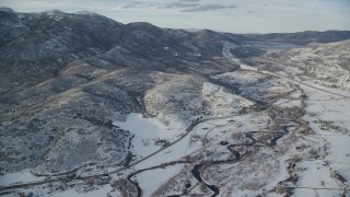 AX127_007 - 5.5K aerial stock footage approach riverside rural homes and mountains with light snow near Midway, Utah