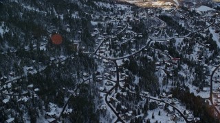 AX127_043E - 5.5K aerial stock footage approach residential neighborhoods in the shadow of a snowy mountain at sunset, Park City, Utah