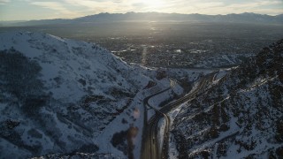 AX127_072 - 5.5K aerial stock footage approach Salt Lake City suburbs from I-80 through Wasatch Range at sunset, Utah