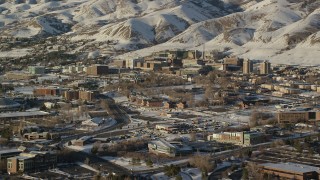 AX127_081 - 5.5K stock footage aerial video orbit University of Utah Hospital with winter snow at sunset, Salt Lake City
