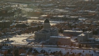 AX127_088E - 5.5K aerial stock footage of circling Utah State Capitol with winter snow on the grounds at sunset, Salt Lake City