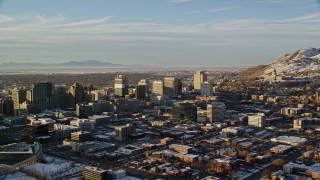 AX127_106 - 5.5K stock footage video of passing by Downtown Salt Lake City near Utah State Capitol with winter snow at sunset