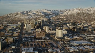 AX127_110 - 5.5K stock footage aerial video of buildings with winter snow in Downtown Salt Lake City at sunset, Utah